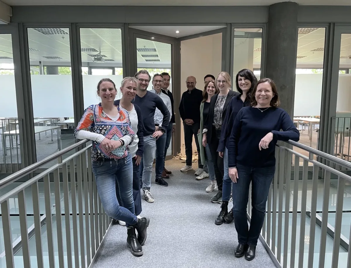 Ausbildungsgruppe der HM-i Business Coach Ausbildung auf der Glasbrücke im Gebäude der ISM Köln